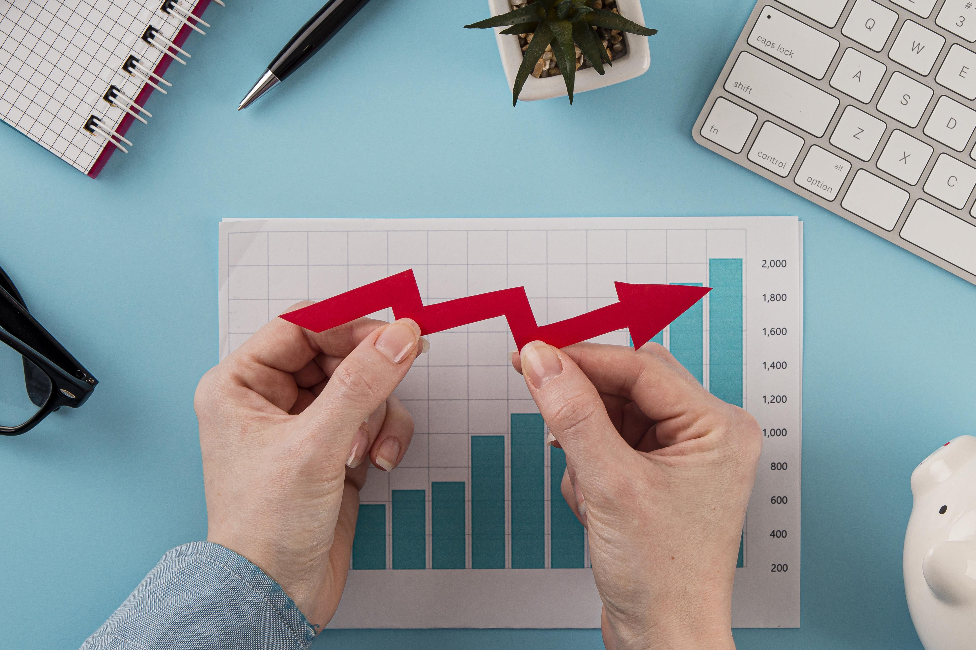 top-view-business-items-with-growth-chart-hands-holding-arrow.jpg